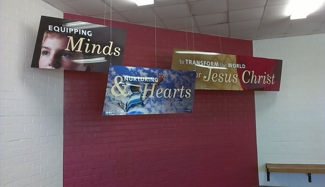 Clear acrylic applied to the back and hanging from the ceiling.