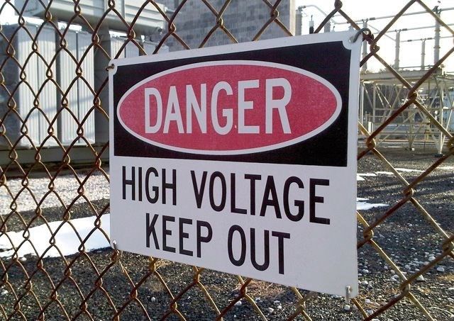 high voltage danger warning sign metal mounted to fence
