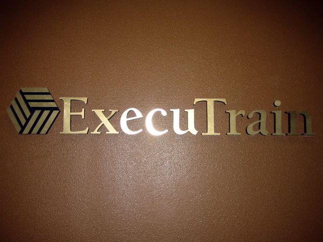 Brushed gold dimensional lettering shows well against the dark wall