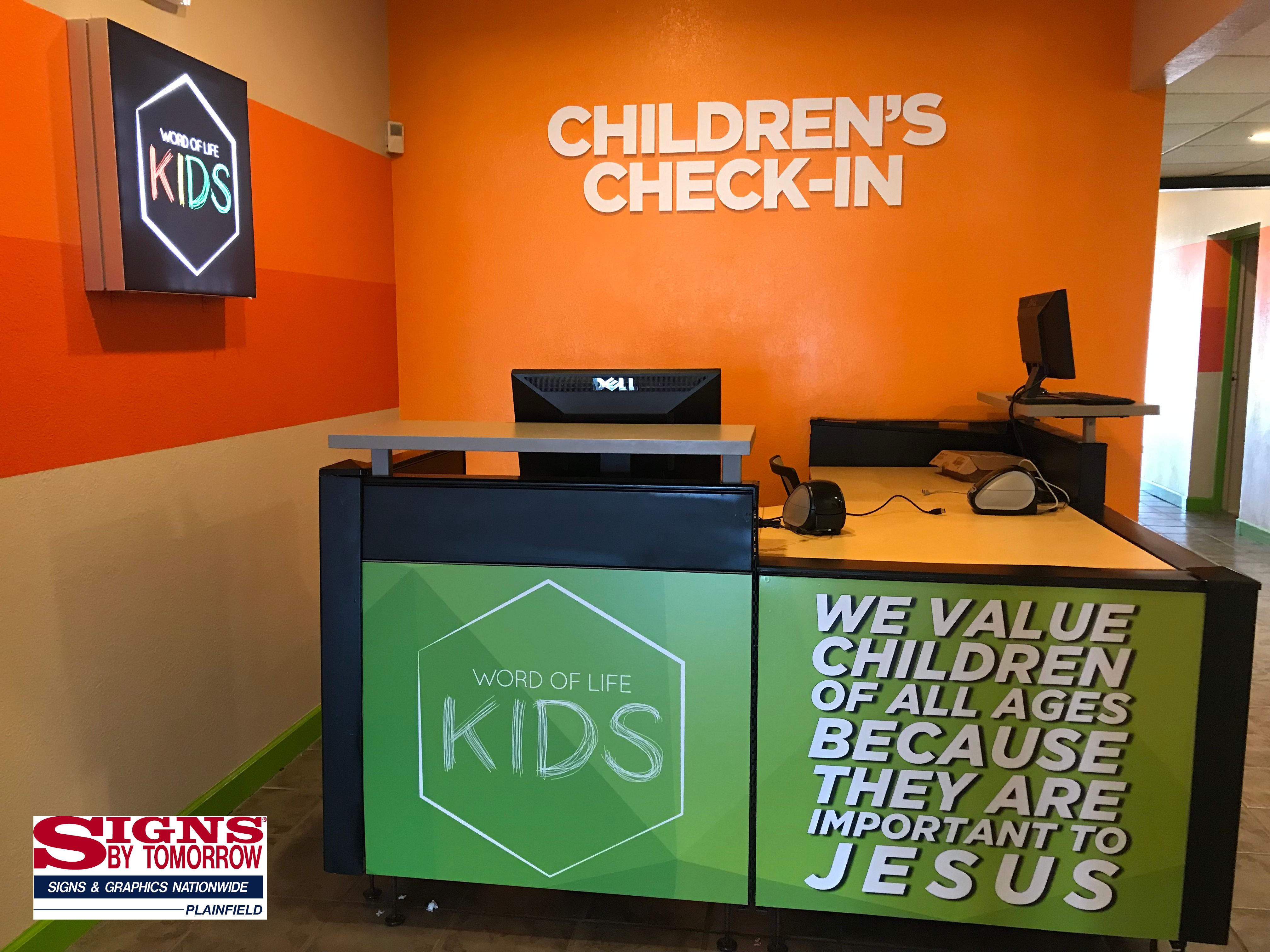 Wrapped desk with dimensional lettering and Illuminated light box