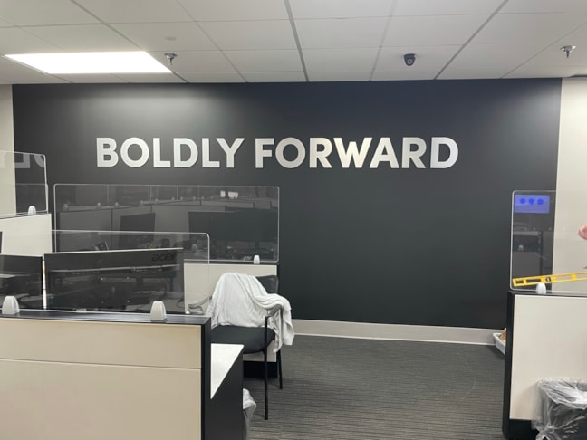 High-contrast dimensional typography transforms standard office walls into powerful, permanent brand expressions.