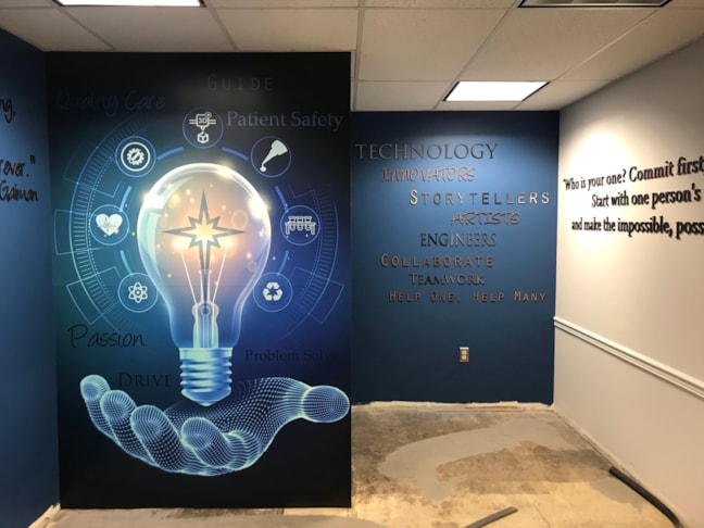 Combining custom large-format wall wraps with architectural 3D lettering to design an immersive, motivational workforce ecosystem with custom environmental and experiential graphic art and design