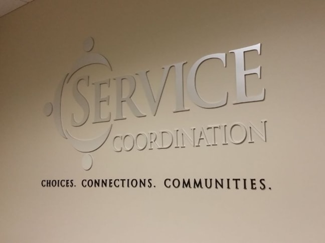 Brushed Silver and Black Acrylic Reception Area Lettering for Service Coordination
